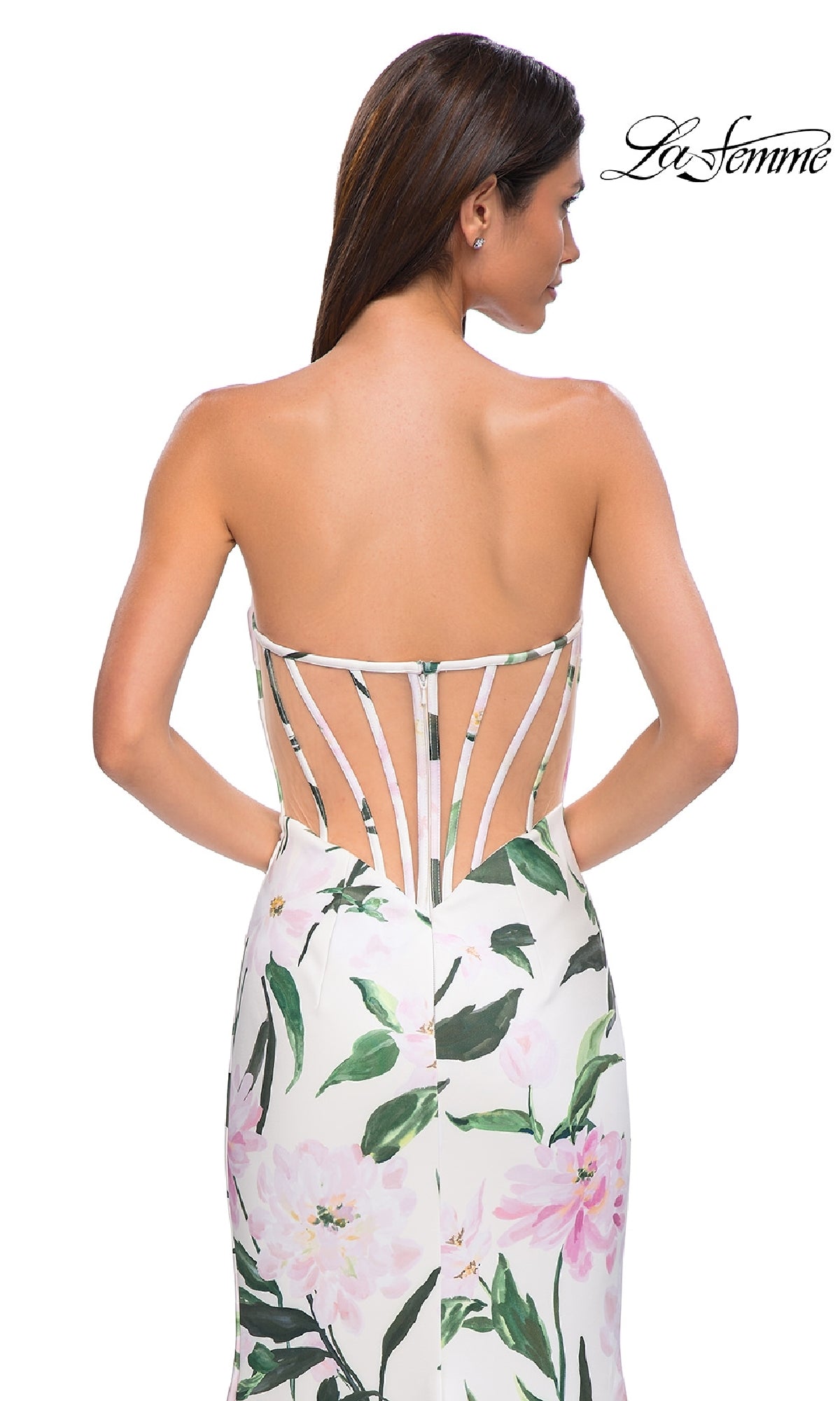 A woman models the La Femme 32752 strapless long print prom dress, featuring a white floral design and a unique open back with thin vertical straps;